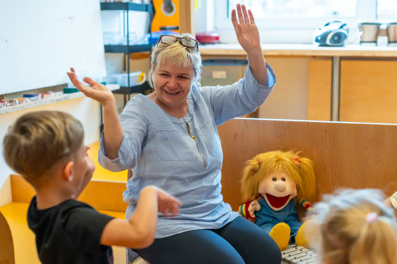 Erzieherin gestaltet den Morgenkreis mit Handpuppe in einer Kita in Niefern-Öschelbronn